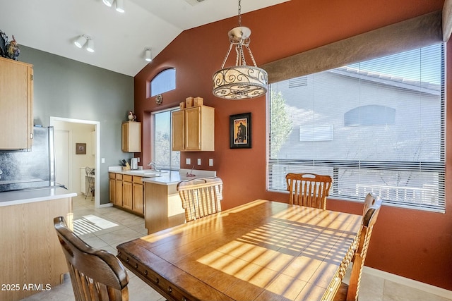 dining space featuring sink, high vaulted ceiling, and light tile patterned flooring