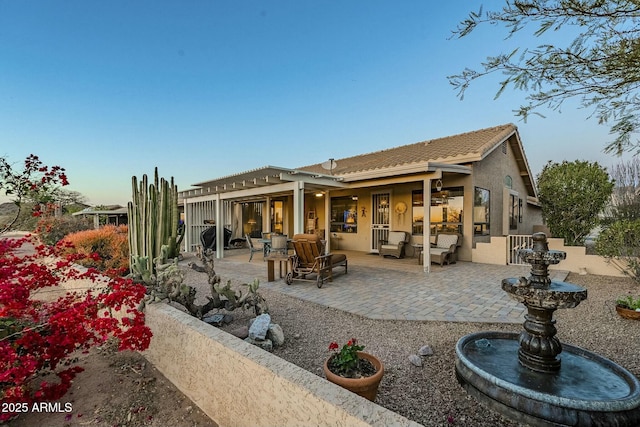 back of house featuring outdoor lounge area and a patio