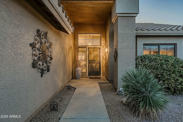 exterior entry at dusk featuring a patio area