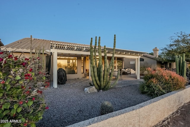 back of property with a pergola and a patio