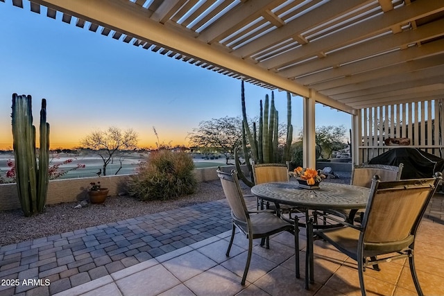 patio terrace at dusk with a pergola and grilling area