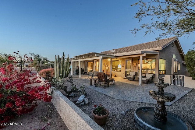 rear view of property featuring an outdoor living space and a patio