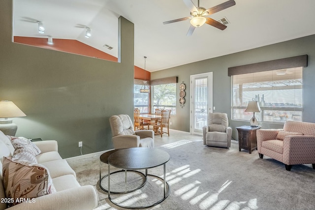 living room featuring ceiling fan, light colored carpet, rail lighting, and vaulted ceiling