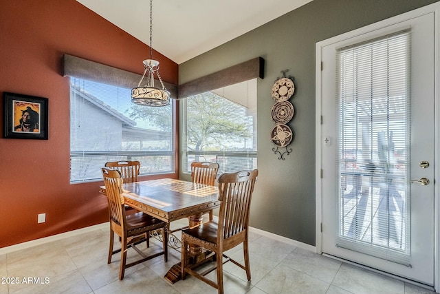 dining space featuring lofted ceiling, a wealth of natural light, and light tile patterned floors