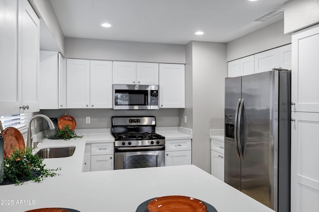 kitchen with a sink, light countertops, white cabinetry, and stainless steel appliances