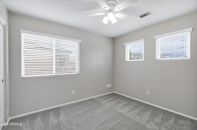 unfurnished room with visible vents, baseboards, carpet, and ceiling fan