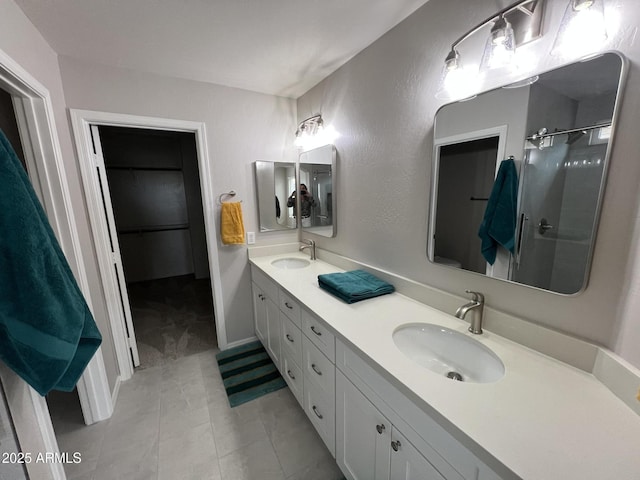 full bathroom with a sink, a walk in closet, a shower with door, and double vanity