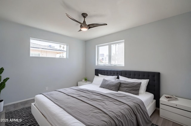 bedroom with baseboards, multiple windows, a ceiling fan, and wood finished floors