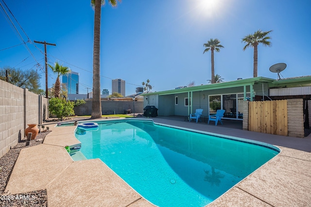 view of swimming pool with a patio, area for grilling, a fenced backyard, and a fenced in pool