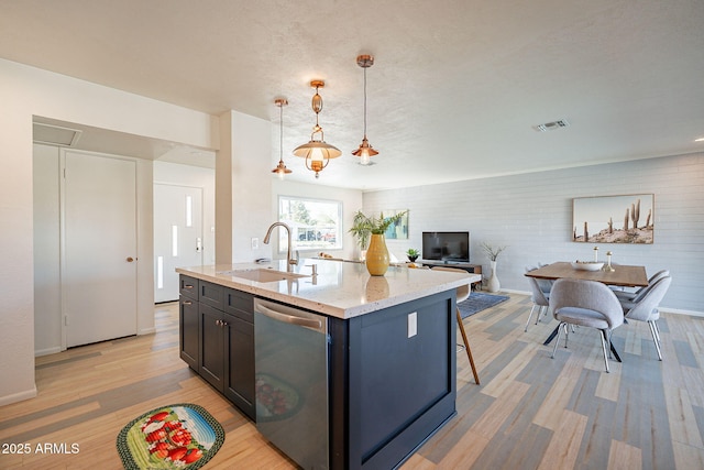 kitchen featuring visible vents, a sink, light wood finished floors, and stainless steel dishwasher