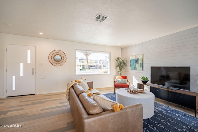 living room with recessed lighting, visible vents, a textured ceiling, wood finished floors, and baseboards