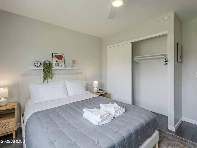 bedroom with a closet, wood finished floors, and baseboards