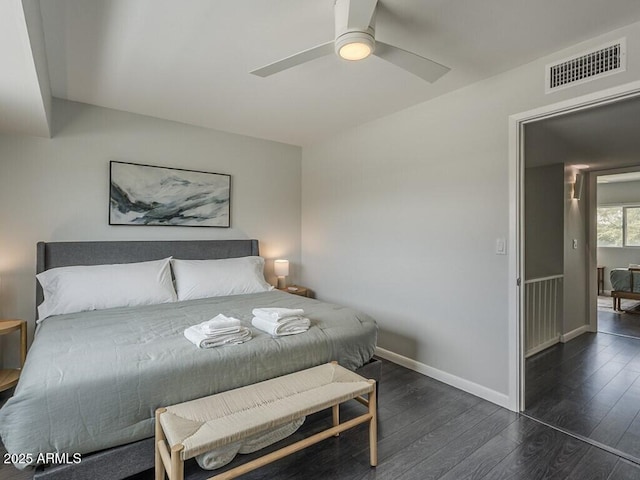 bedroom featuring dark wood-style flooring, a ceiling fan, and baseboards