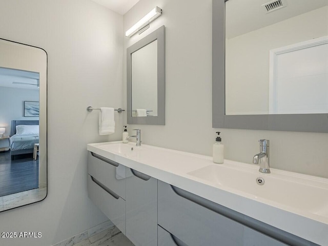 ensuite bathroom featuring marble look tile flooring and double vanity