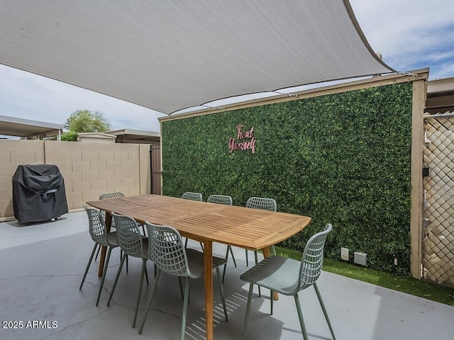 view of patio with grilling area, outdoor dining area, and fence
