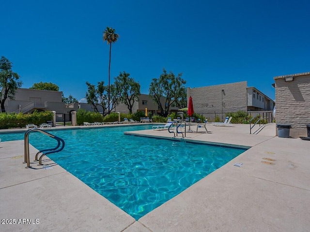 community pool featuring fence and a patio area