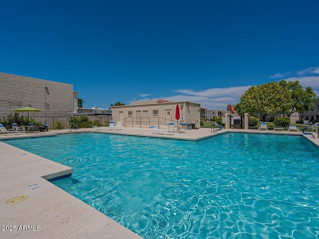 community pool with fence and a patio