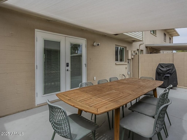 view of patio / terrace featuring french doors, fence, outdoor dining area, and a grill