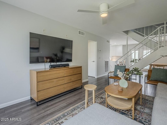 living room with wood finished floors, baseboards, stairs, and a ceiling fan