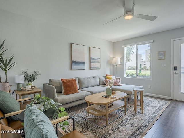 living room featuring wood finished floors, a ceiling fan, and baseboards