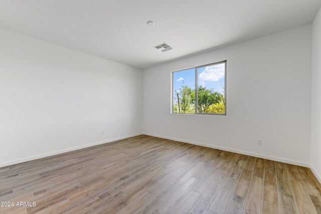 empty room with light hardwood / wood-style flooring