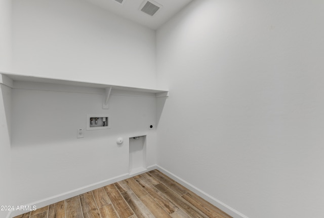 washroom with washer hookup, gas dryer hookup, light hardwood / wood-style flooring, and electric dryer hookup