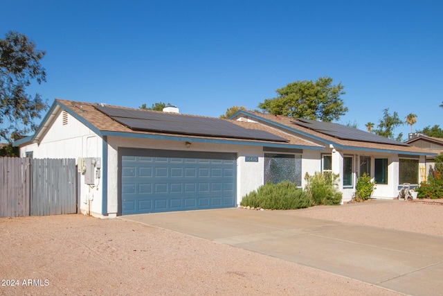 view of front facade with solar panels and a garage