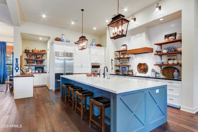 kitchen with white cabinetry, pendant lighting, stainless steel appliances, and a large island