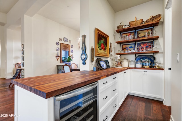 kitchen with dark wood-type flooring, wood counters, white cabinetry, and beverage cooler