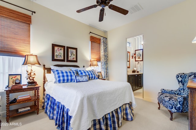 bedroom featuring light carpet, ceiling fan, connected bathroom, and multiple windows