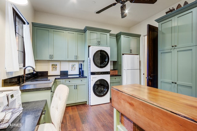 kitchen with dark hardwood / wood-style floors, sink, green cabinets, stacked washing maching and dryer, and white refrigerator