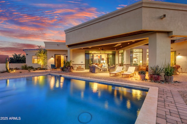 pool at dusk featuring a patio area