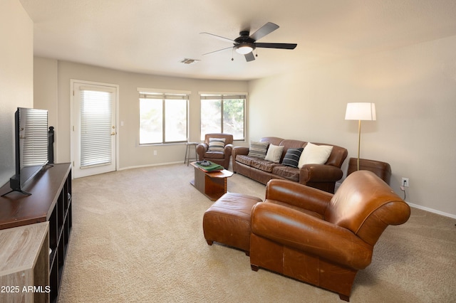 living room with carpet floors, a ceiling fan, visible vents, and baseboards