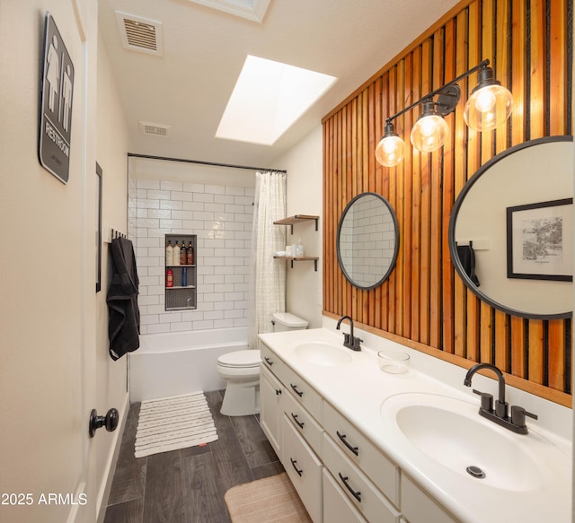 bathroom featuring visible vents, a skylight, and a sink