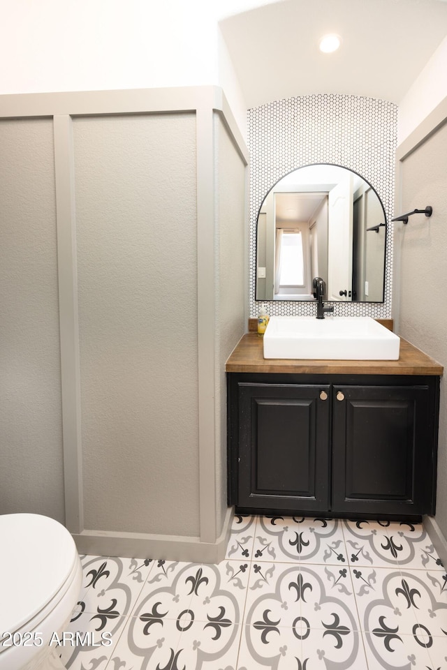 bathroom with tile patterned floors, baseboards, vanity, and toilet