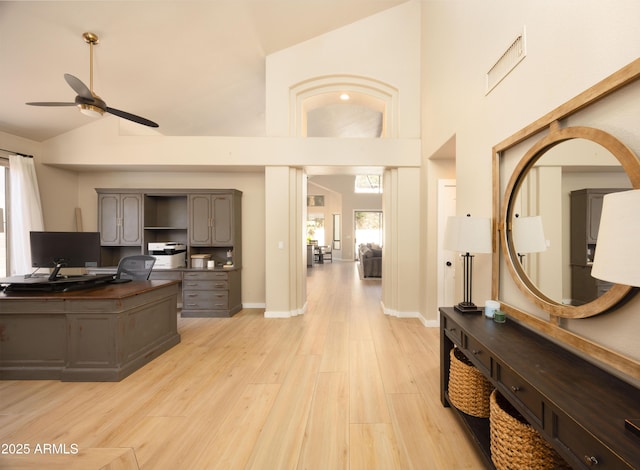 office area with light wood-style floors, baseboards, a ceiling fan, and high vaulted ceiling