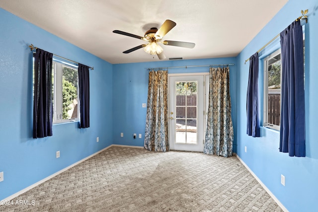 spare room with light colored carpet and ceiling fan