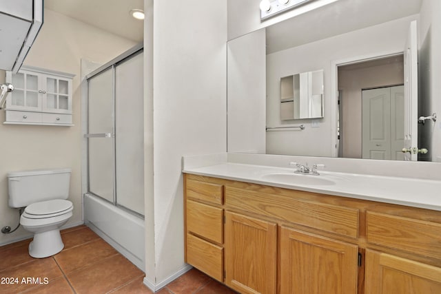 full bathroom featuring toilet, tile patterned flooring, vanity, and enclosed tub / shower combo