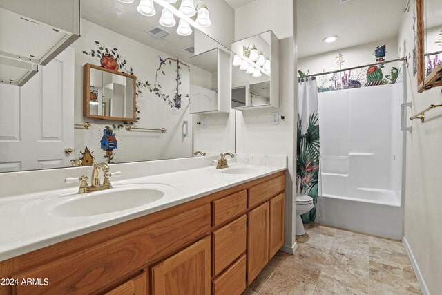 bathroom with a sink, toilet, double vanity, and visible vents