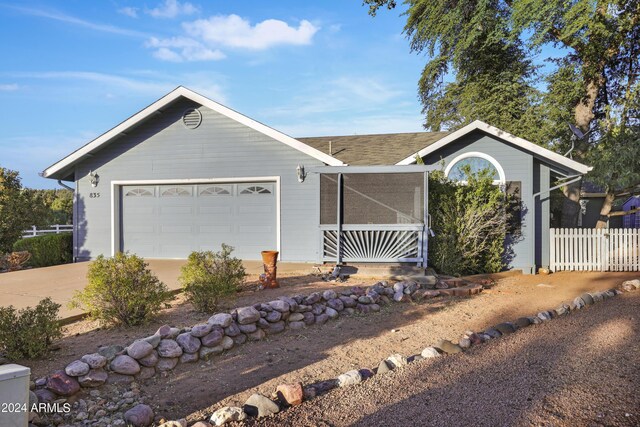ranch-style house featuring fence, an attached garage, driveway, and roof with shingles