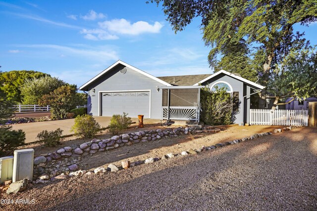 single story home with concrete driveway, fence, and a garage
