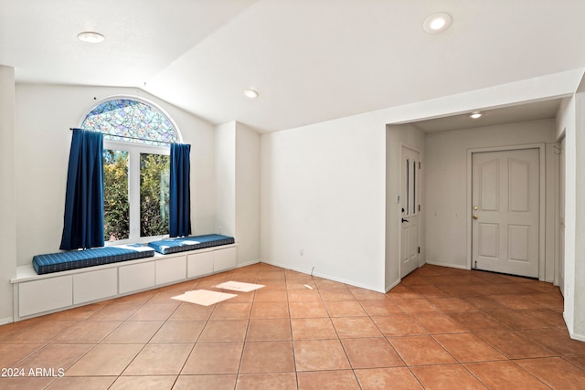 tiled empty room with vaulted ceiling