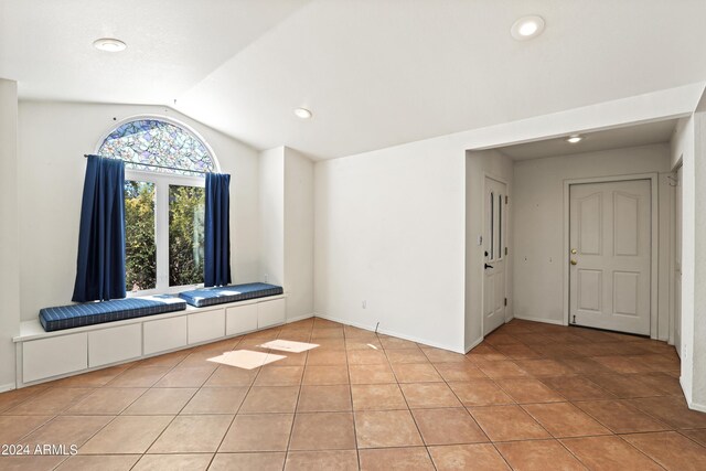 spare room featuring light tile patterned floors, baseboards, recessed lighting, and lofted ceiling