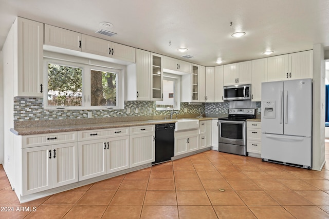 kitchen featuring backsplash, appliances with stainless steel finishes, sink, and white cabinetry