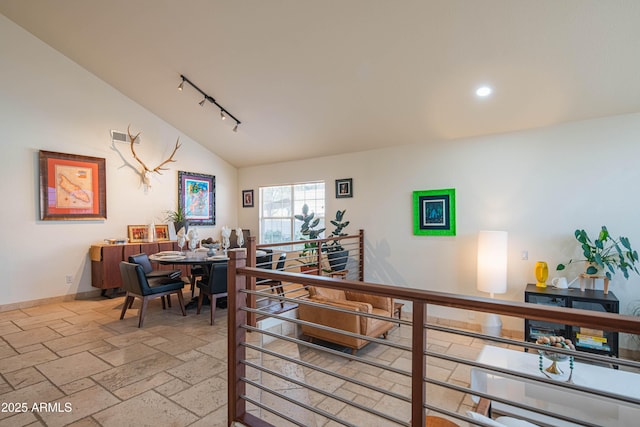 interior space with baseboards, vaulted ceiling, stone tile flooring, track lighting, and recessed lighting