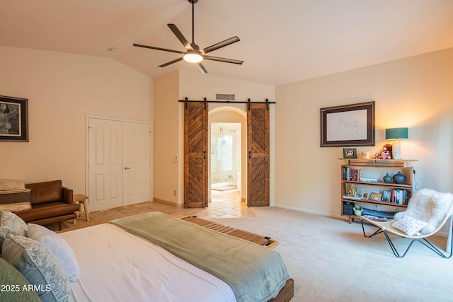 bedroom featuring a barn door, light carpet, visible vents, vaulted ceiling, and a closet