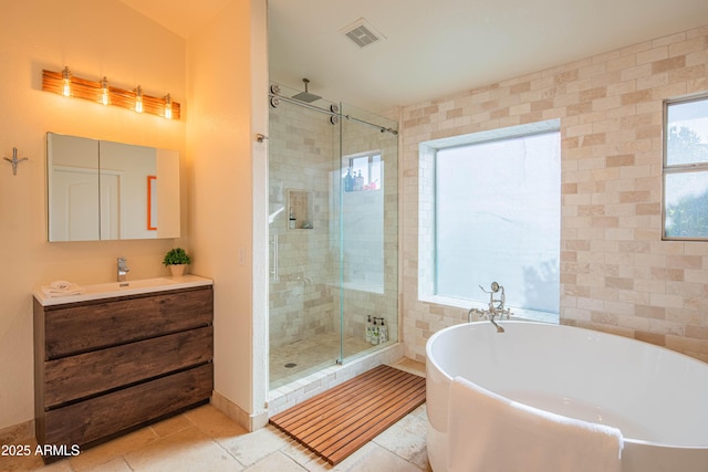 full bathroom with visible vents, a freestanding bath, a shower stall, vanity, and tile patterned floors