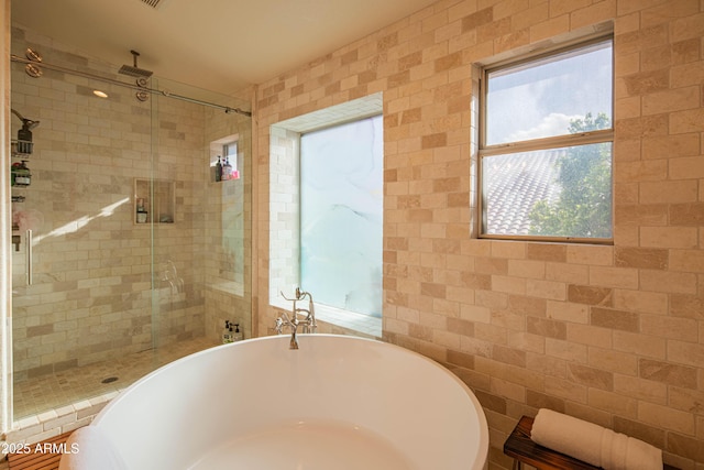 full bath featuring a freestanding tub and a stall shower