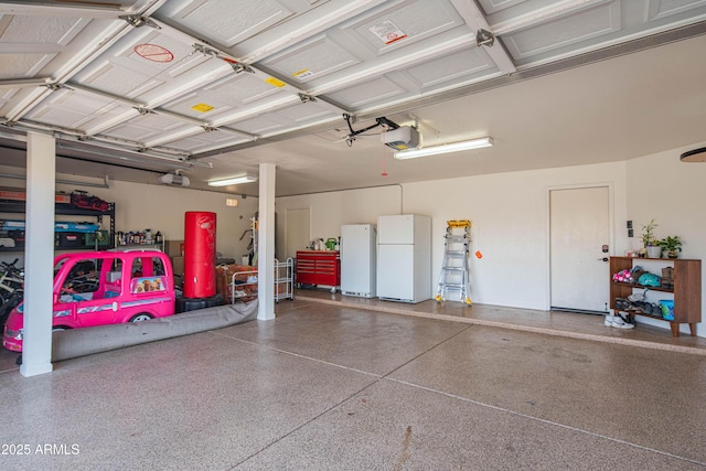 garage with a garage door opener and freestanding refrigerator