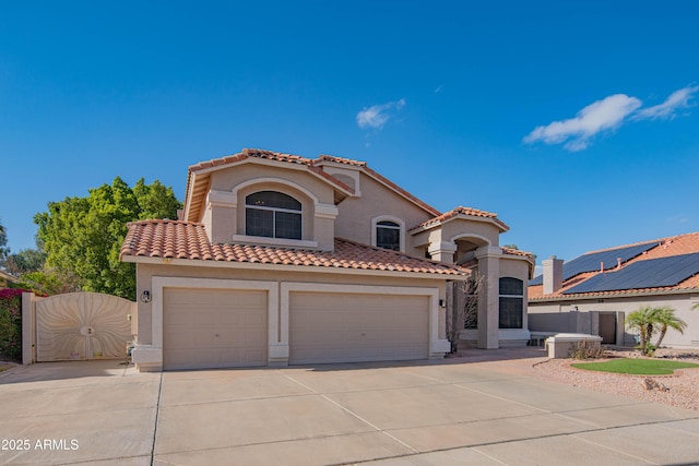 mediterranean / spanish house with concrete driveway, a tiled roof, and stucco siding